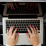 Person typing on laptop keyboard